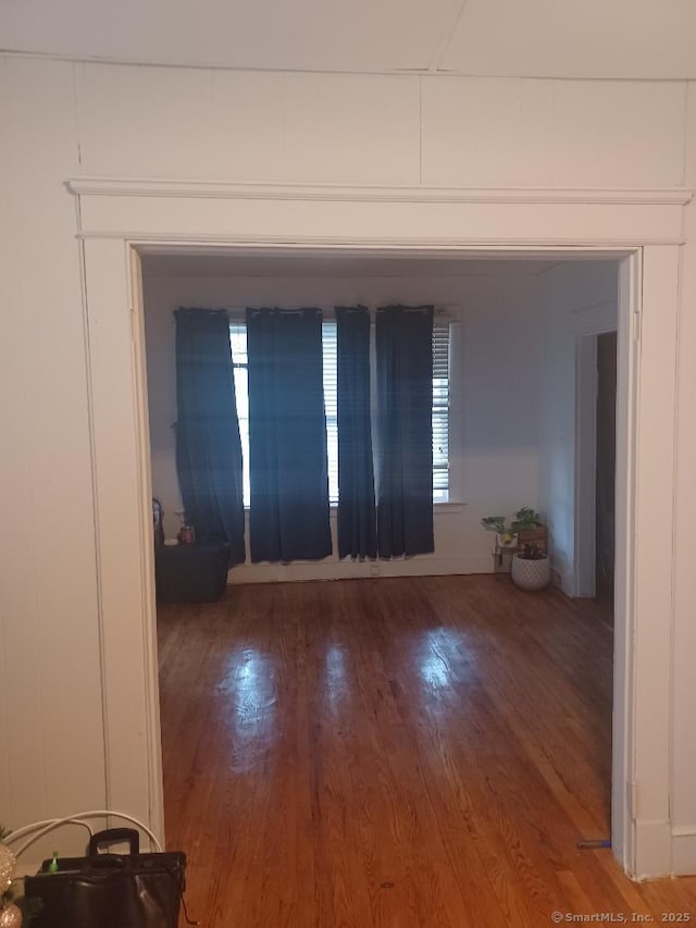 empty room with wood-type flooring and a healthy amount of sunlight