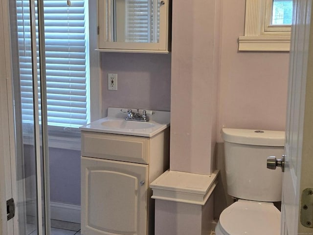 bathroom with toilet, tile patterned floors, and vanity