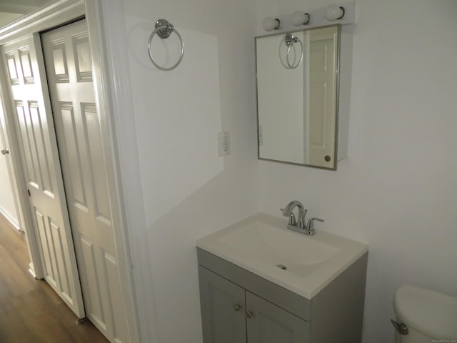 bathroom featuring vanity, wood-type flooring, and toilet