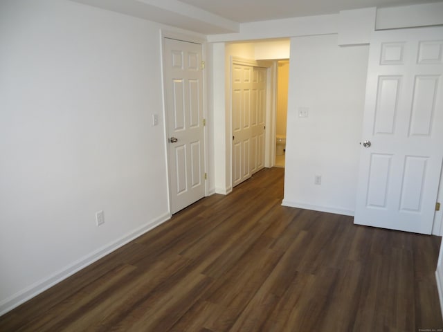 unfurnished bedroom with dark hardwood / wood-style flooring