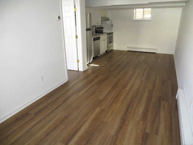 unfurnished living room featuring dark hardwood / wood-style flooring and a baseboard radiator