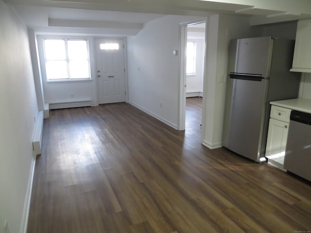 kitchen with stainless steel appliances, dark hardwood / wood-style flooring, a baseboard heating unit, and white cabinets