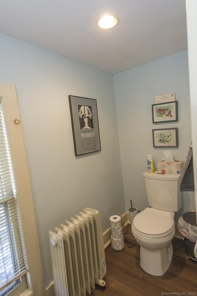 bathroom with radiator, wood-type flooring, and toilet