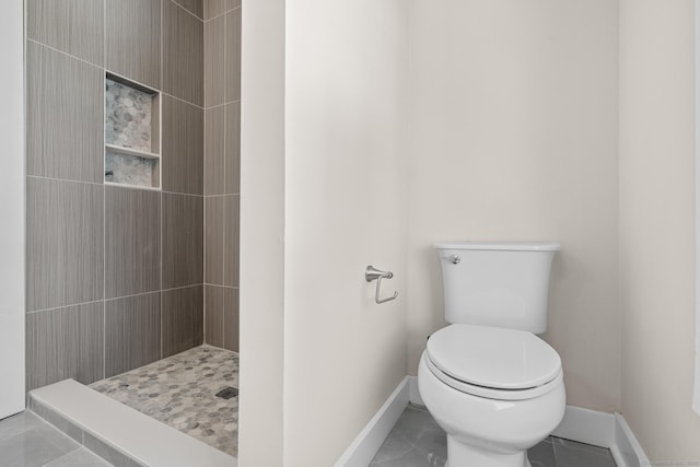 bathroom with tiled shower and toilet