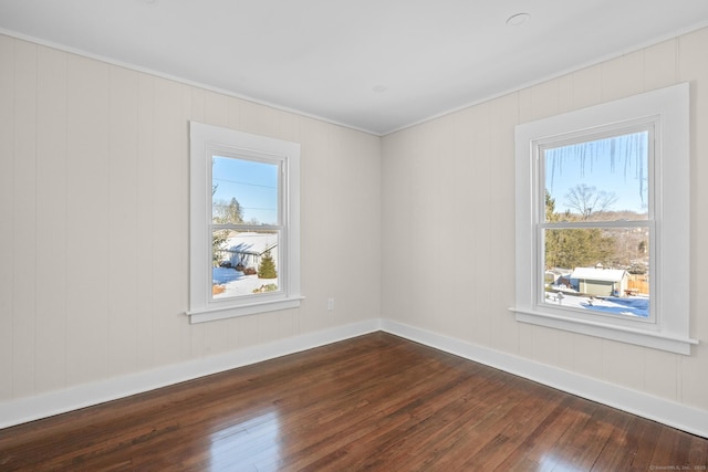 spare room with a healthy amount of sunlight and hardwood / wood-style floors