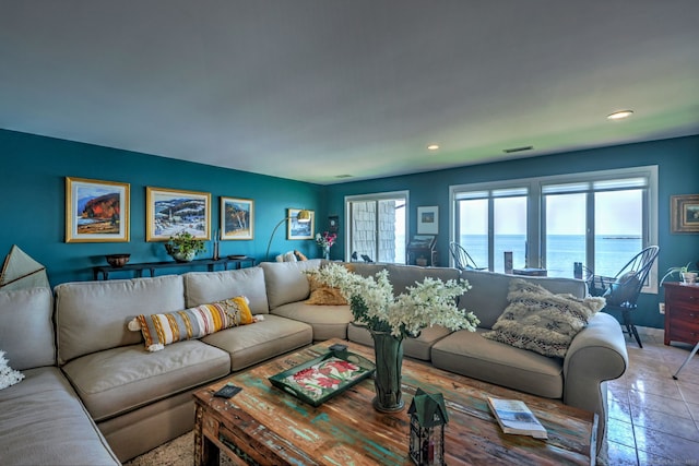 tiled living room with a water view and a wealth of natural light