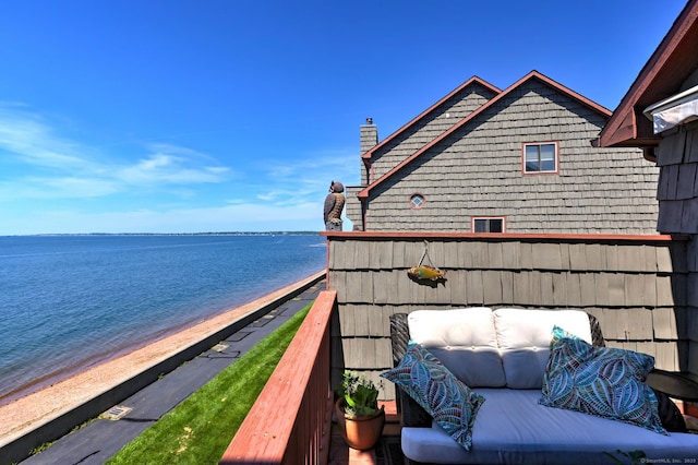 balcony with a water view and a view of the beach