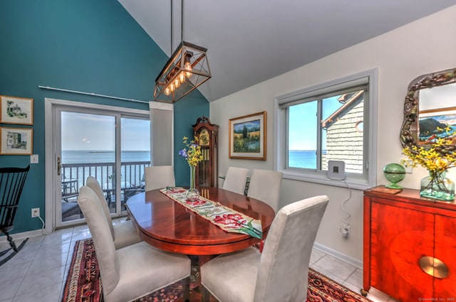 tiled dining room with lofted ceiling and a water view