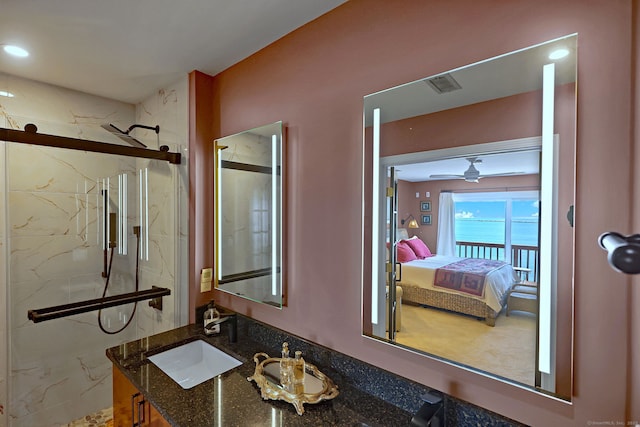 bathroom with a shower with shower door, ceiling fan, and vanity