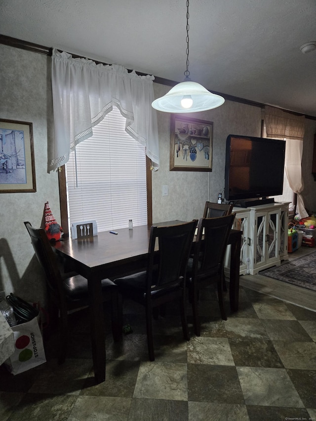 dining room with crown molding and a textured ceiling