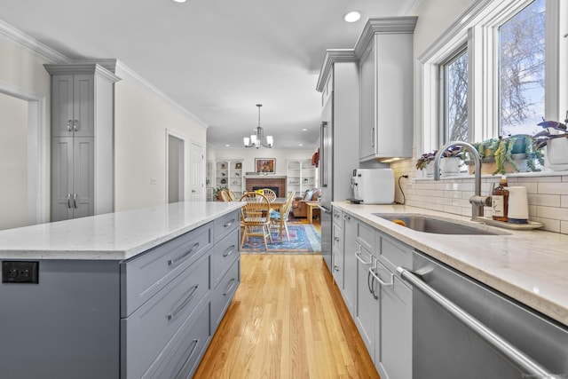 kitchen with crown molding, gray cabinets, light wood-style flooring, a sink, and dishwasher