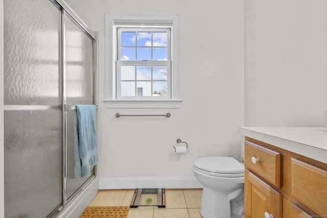 full bath with baseboards, toilet, tile patterned floors, vanity, and a shower stall