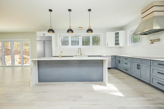 1240 Westport Tpke, Fairfield, CT 06824 - kitchen featuring a sink, light wood finished floors, built in fridge, wall chimney exhaust hood, and backsplash