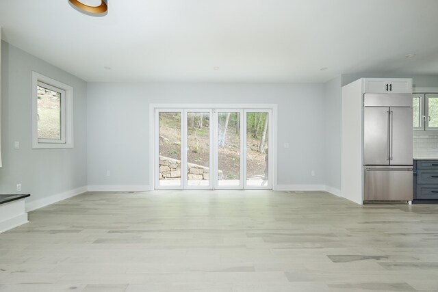 1240 Westport Tpke, Fairfield, CT 06824 - unfurnished living room featuring baseboards and light wood-style flooring