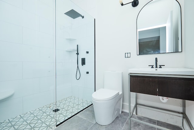 bathroom with vanity, toilet, and tiled shower