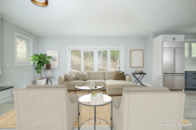 living room with a healthy amount of sunlight and light hardwood / wood-style flooring