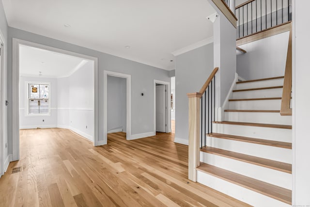 staircase with crown molding and hardwood / wood-style flooring