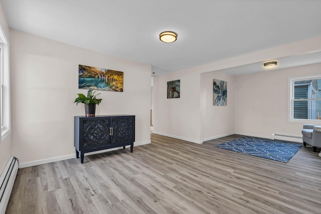 living area with light hardwood / wood-style flooring and a baseboard radiator