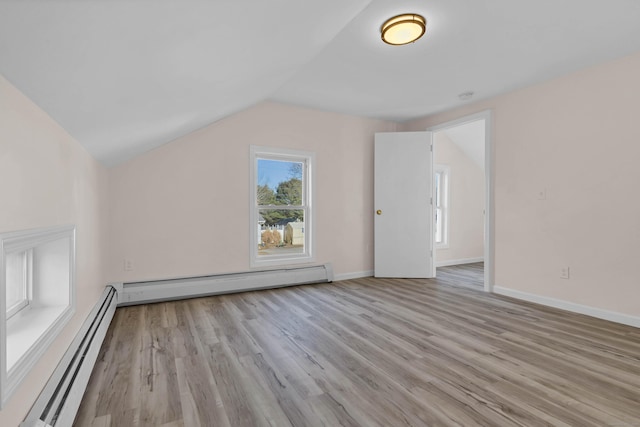 additional living space featuring light hardwood / wood-style floors, a baseboard heating unit, and lofted ceiling