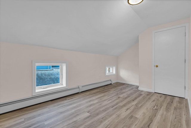 bonus room with lofted ceiling, light hardwood / wood-style flooring, and a baseboard heating unit