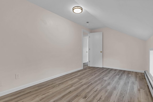 bonus room with light hardwood / wood-style floors, a baseboard heating unit, and lofted ceiling