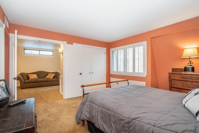 bedroom featuring multiple windows, light colored carpet, and a closet