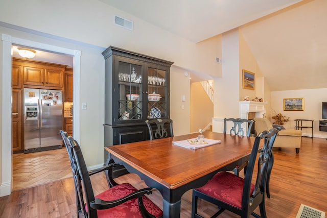 dining space featuring vaulted ceiling and light wood-type flooring