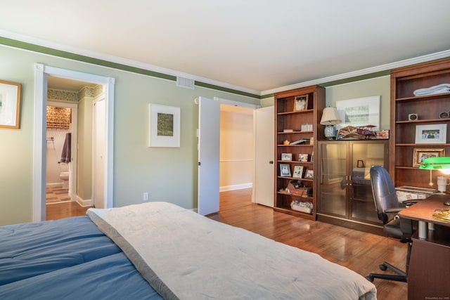 bedroom featuring crown molding, connected bathroom, and hardwood / wood-style floors