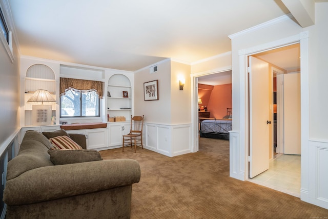 carpeted living room featuring crown molding and built in shelves