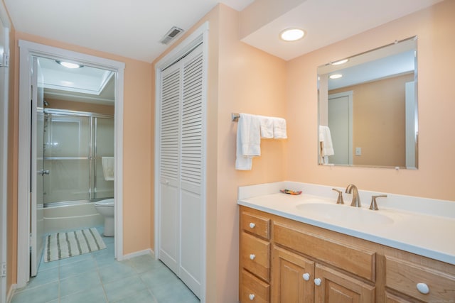 full bathroom featuring vanity, tile patterned flooring, toilet, and combined bath / shower with glass door