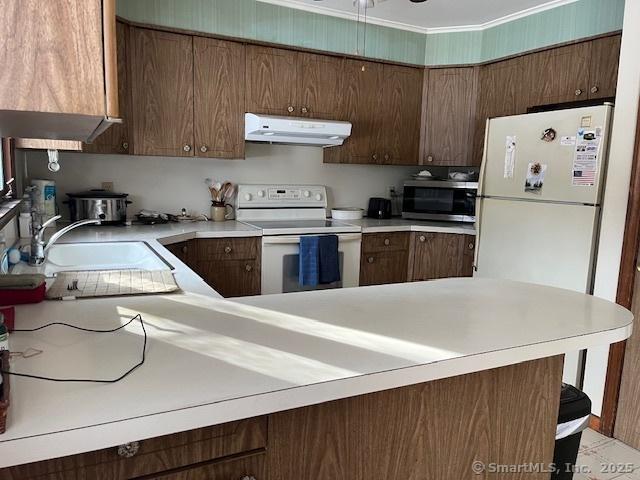 kitchen featuring sink, white appliances, and kitchen peninsula