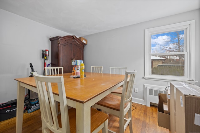 dining area with radiator and light hardwood / wood-style floors