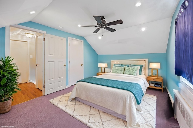 carpeted bedroom with radiator heating unit, ceiling fan, and vaulted ceiling