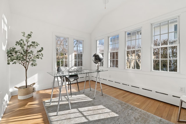 sunroom / solarium featuring vaulted ceiling and baseboard heating