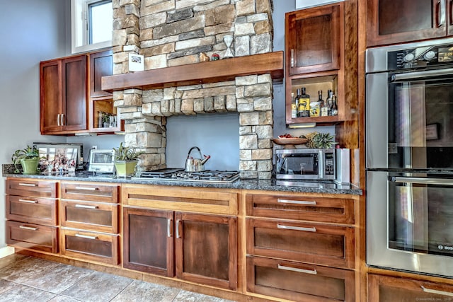 kitchen with dark stone counters and appliances with stainless steel finishes