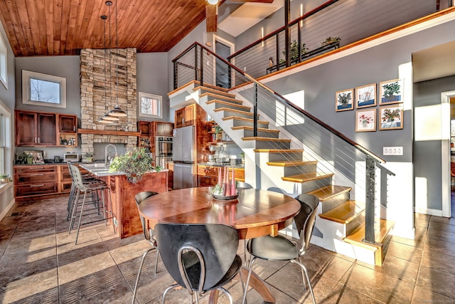 dining area with wood ceiling and high vaulted ceiling