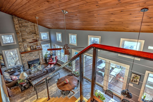 unfurnished living room with high vaulted ceiling, wooden ceiling, ceiling fan, and a fireplace