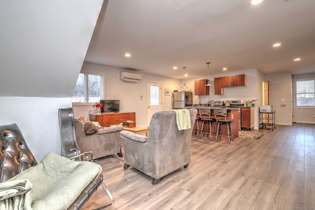 living room with light wood-type flooring and a wall unit AC