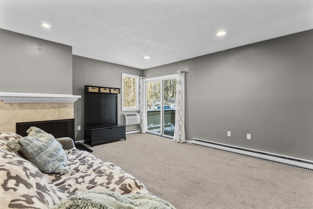 carpeted bedroom featuring a baseboard heating unit, access to exterior, and a textured ceiling