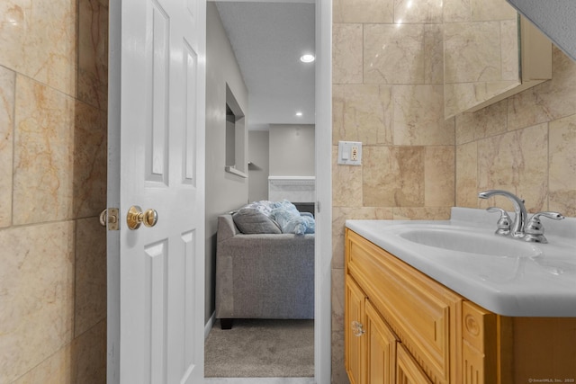 bathroom featuring vanity and tile walls