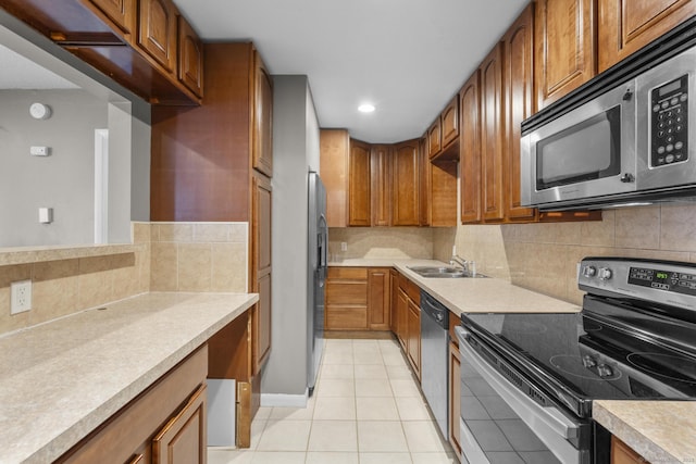 kitchen with backsplash, stainless steel appliances, sink, and light tile patterned floors