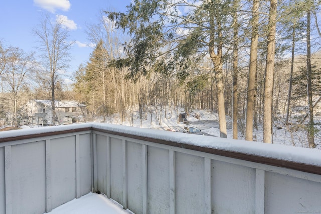 view of snow covered back of property