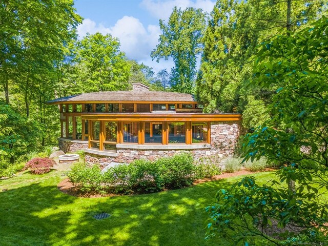 22 Father Peters Ln, New Canaan, CT 06840 - rear view of property with stone siding, a yard, and a chimney