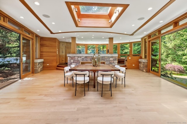 interior space featuring a skylight, wooden walls, and light wood-type flooring