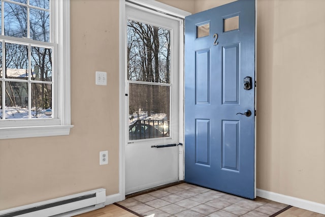 tiled entryway with baseboard heating and plenty of natural light