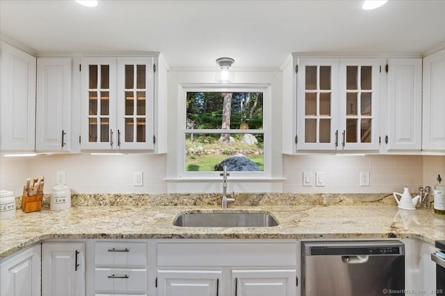 kitchen with backsplash, glass insert cabinets, white cabinetry, a sink, and dishwasher