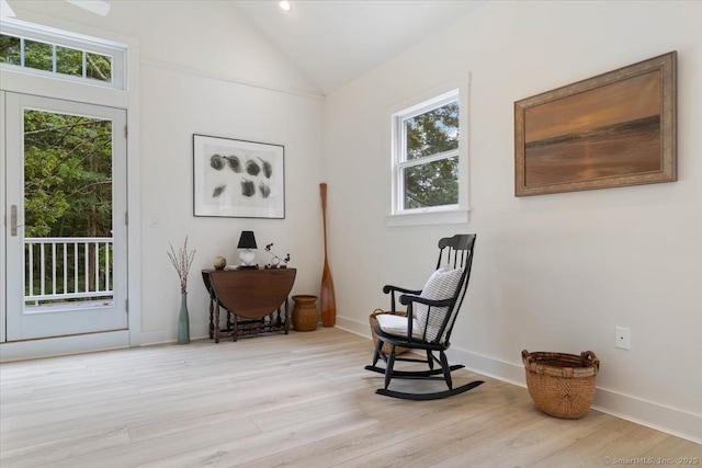 living area with vaulted ceiling, light wood finished floors, plenty of natural light, and baseboards