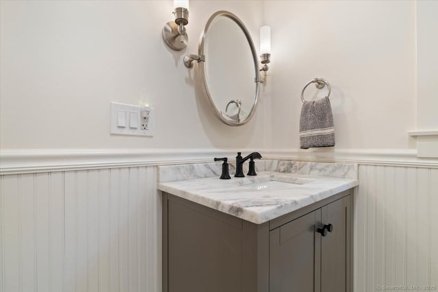 bathroom with a wainscoted wall and vanity