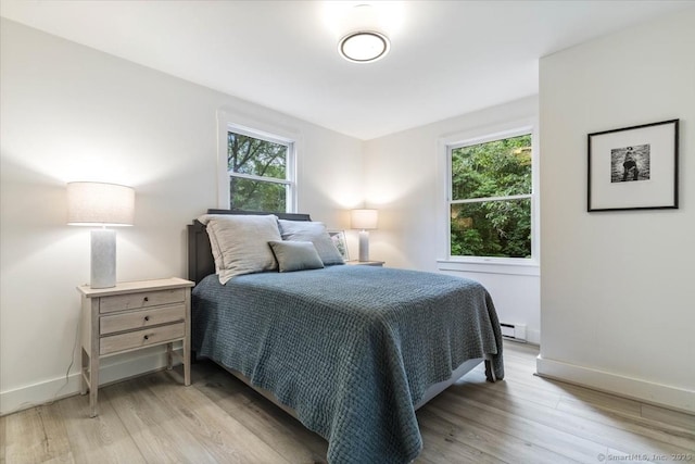 bedroom with light wood-type flooring and baseboards