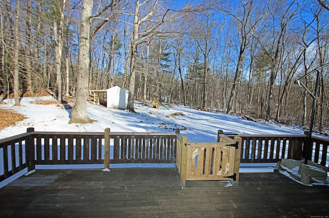 snow covered deck featuring a shed